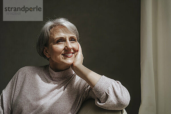 Mature woman sitting and smiling at home
