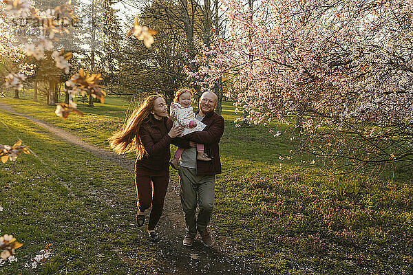 Glückliche Familie läuft mit Tochter im Park