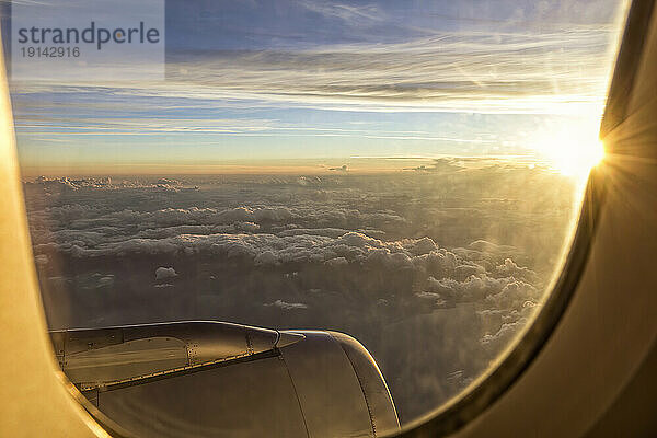 Wolkengebilde aus dem Flugzeugfenster bei Sonnenuntergang
