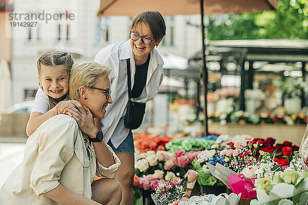 Glückliche Tochter genießt es mit lesbischem Paar im Blumenladen