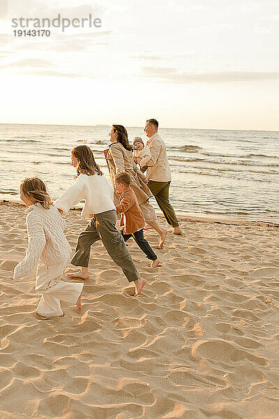 Fröhliche Familie läuft und genießt gemeinsam am Strand