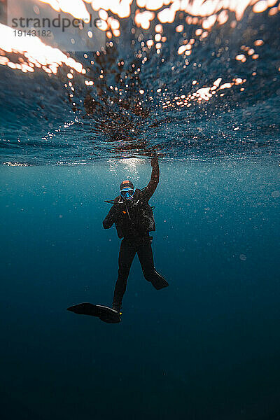 Junger Mann taucht unter Wasser