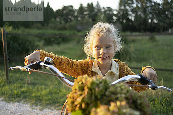 Lächelndes blondes Mädchen mit Fahrradgriff