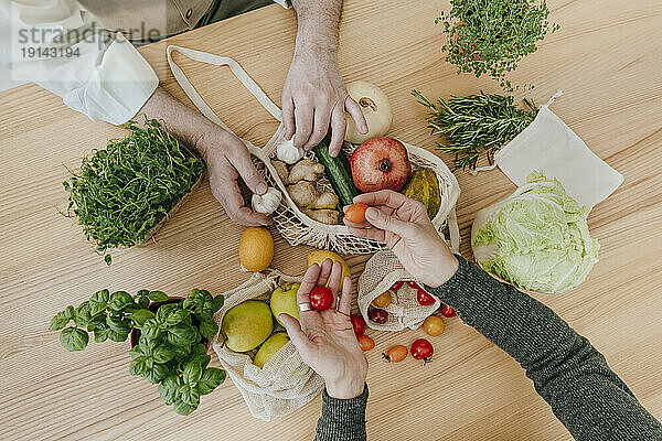 Paar packt Obst und Gemüse aus Netzbeutel aus