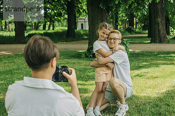 Frau fotografiert Mutter  die Tochter im Park umarmt