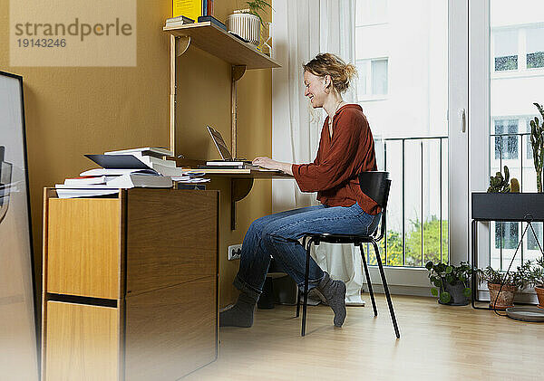 Junger Freiberufler arbeitet im Heimbüro am Laptop