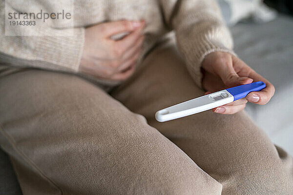 Frau überprüft Schwangerschaftstestset