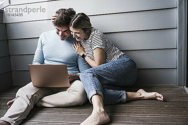Glücklicher Mann und Frau  die Laptop vor der Wand benutzen