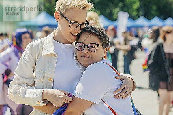 Glückliches lesbisches Paar  das sich bei der Gay-Pride-Veranstaltung umarmt