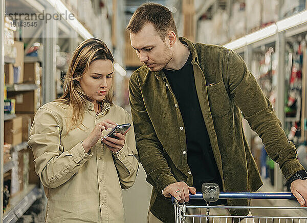 Junges Paar kauft im Supermarkt ein