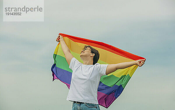 Glückliche Lesbe mit Regenbogenfahne