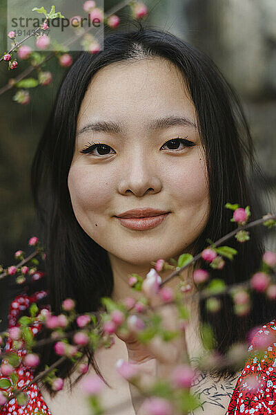 Lächelnde junge Frau mit rosa Blumen