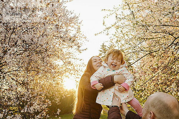 Familie hat Spaß mit Tochter im Park an einem sonnigen Tag