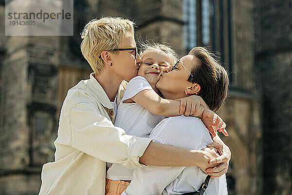 Lesbisches Paar küsst Tochter an sonnigem Tag