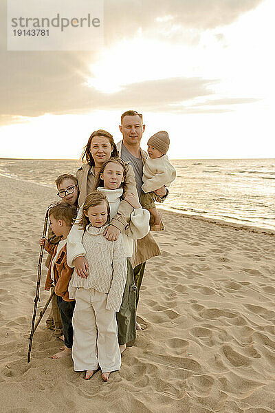 Glückliche Familie  die zusammen am Strand steht