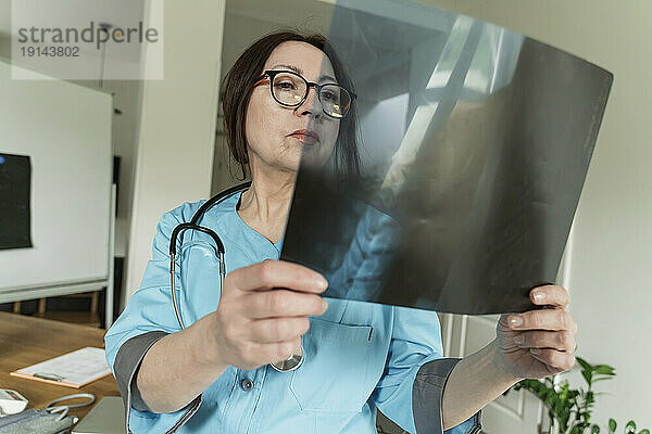 Konzentrierter Arzt untersucht Röntgenaufnahmen in der Arztpraxis