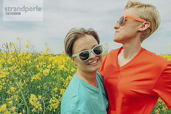 Glückliches lesbisches Paar mit Sonnenbrille auf dem Feld