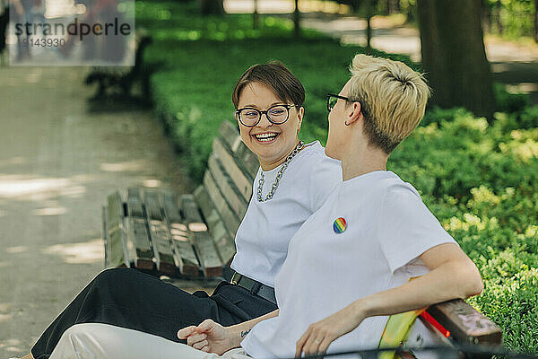 Glückliche Lesben sitzen auf einer Bank im Park