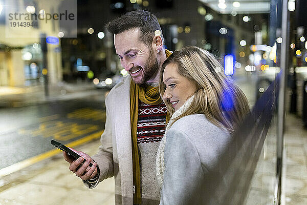 Reflexion von Mann und Frau  die ein Smartphone benutzen