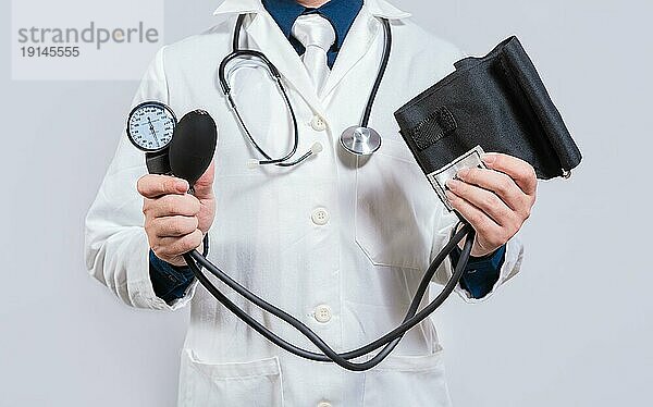 Arzt hält Blutdruckmessgerät isoliert. Arzt Hände halten manuelle Sphygmomanometer isoliert