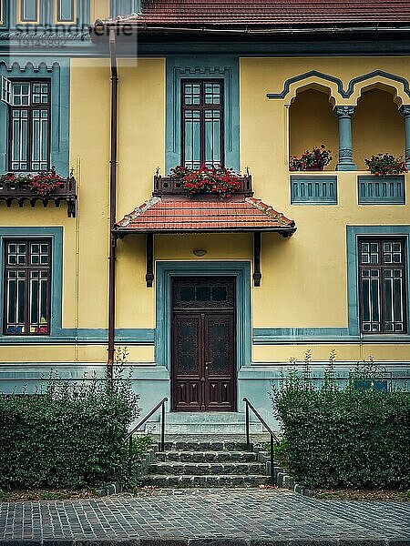 Bunte Hausfassade  Vintagestil mit Retro Veranda und Markise. Traditionelles europäisches Gebäude außen  Frontansicht an der Eingangstür