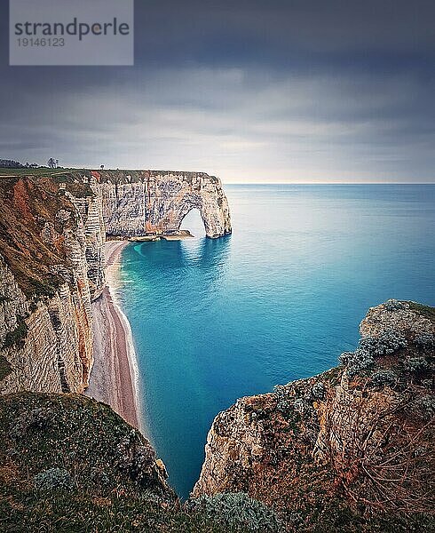 Idyllischer Blick auf den natürlichen Bogen Porte d'Aval bei den berühmten Klippen von Etretat  umspült vom Atlantik  Normandie  Frankreich. Sightseeing Küstenlandschaft  schöne natürliche Bucht mit Sandstrand