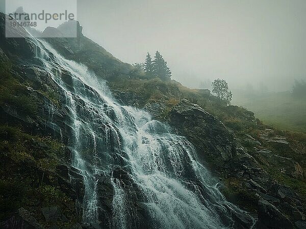 (Capra) Wasserfall auf der Transfagarasan Route in den rumänischen Karpaten. Idyllische Szene mit einem großen Fluss  der an einem nebligen Herbstmorgen durch die Felsen fließt