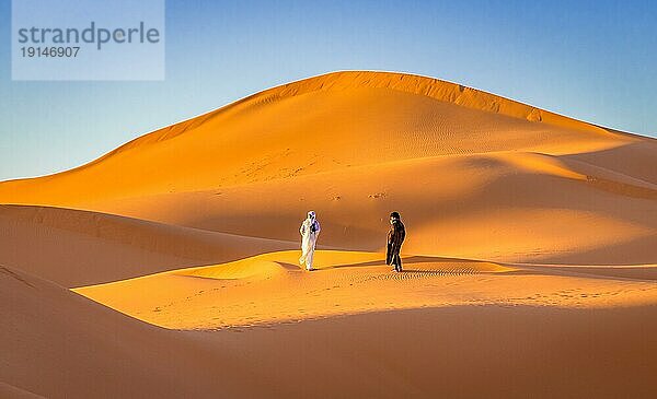 Merzouga  Marokko am 24. Februar 2018: Zwei Berber in der orangefarbenen Saharawüste Merzouga  Marokko  Afrika