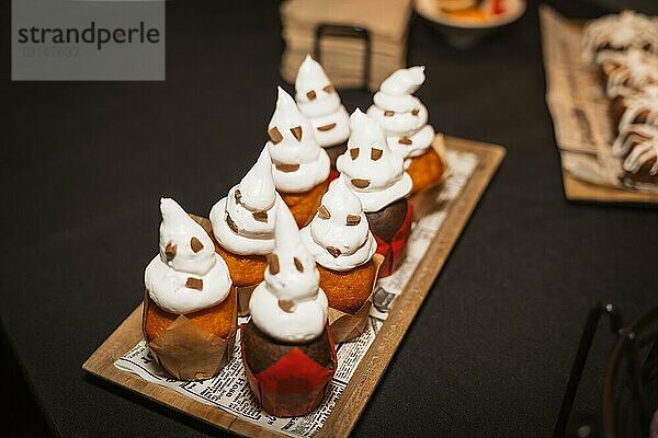 Halloween Lebensmittel und Süßigkeiten in Form von Kürbissen auf einer Party  Geister Cupcakes aus Schokolade