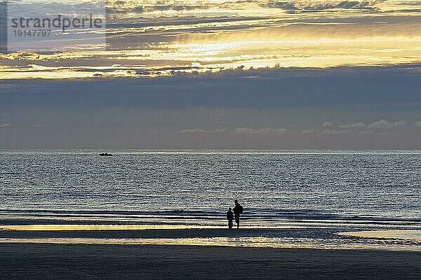 Sonnenutergang an der belgischen Küste  Silhouette von Vater und Sohn am Strand  De Haan  Le Coq  Westflandern  Belgien  Europa