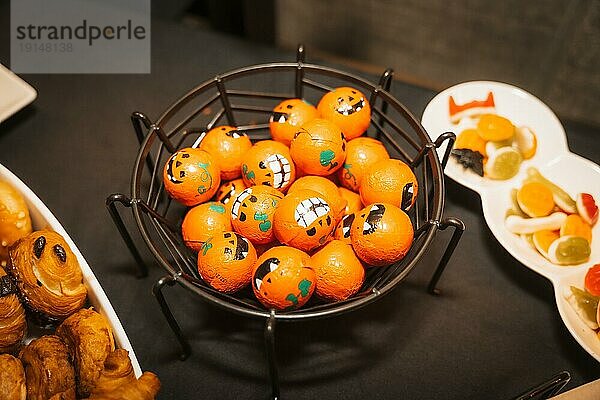 Kürbisförmige Halloween Süßigkeiten und Essen auf einer Party  verpackt mit Kürbissen in einigen Pralinen