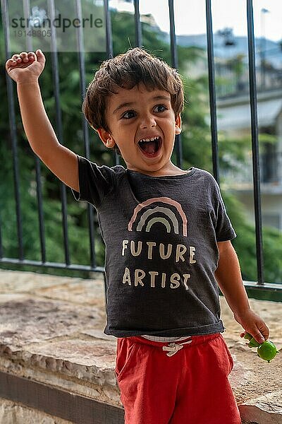 Porträt eines sehr fröhlichen zweijährigen Jungen  der die Sommerferien genießt