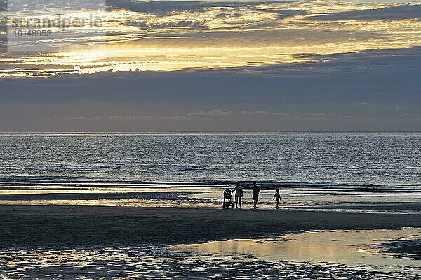 Sonnenuntergang an der belgischen Küste  Silhouette einer Familie mit Kind und Kinderwagen am Strand  De Haan  Le Coq  Westflandern  Belgien  Europa