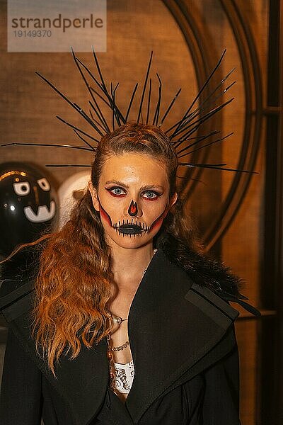 Halloweenparty mit Freunden in einer Diskothek  Porträt einer Frau mit bemaltem Gesicht und Stacheln