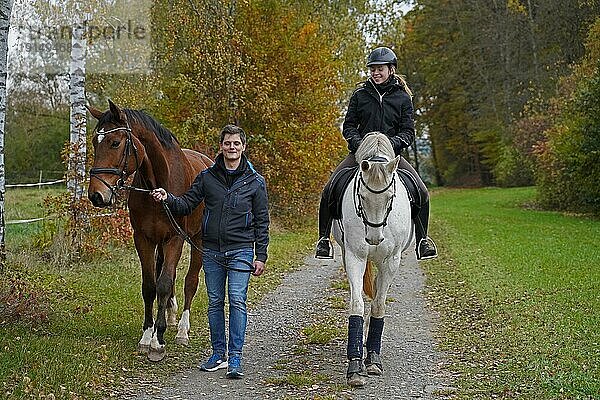 Shooting mit braunem Rheinländerwallach  weißer Stute  ihrem Reiter und Freund