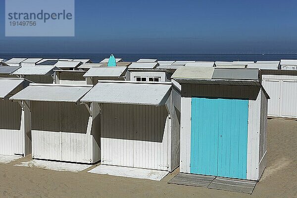 Einheitlich weiße Strandhütten  eine davon türkisfarbig gestrichen  türkisfarbiges Surfbrett  Blankenberge  belgische Küste  Westflandern  Belgien  Europa