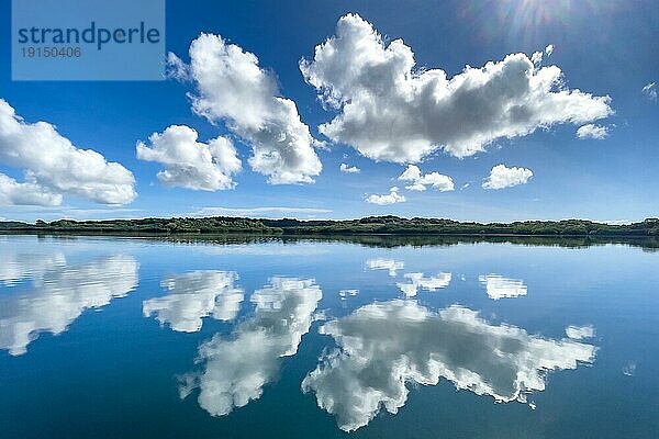 Spiegelung von Wolken Altocumulus vor blauer Himmel spiegeln sich über in Pazifik Stiller Ozean ohne keine Wellen mit in spiegelglatte Meeresoberfläche Wasseroberfläche spiegelglattes Meer  in Bildmitte schmale gespiegelte Silhouette von Südseeinsel mit tropischer grüner Bewuchs tropische Vegetation  Pazifik  Insel Yap  Yap State  Karolineninseln  FSM  Föderierte Staaten von Mikronesien  Australien  Ozeanien