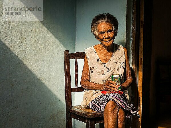 Baracoa  Kuba am 7. Januar 2016: In einem kubanischen Haus genießt eine alte Frau ein Bier in der Sonne