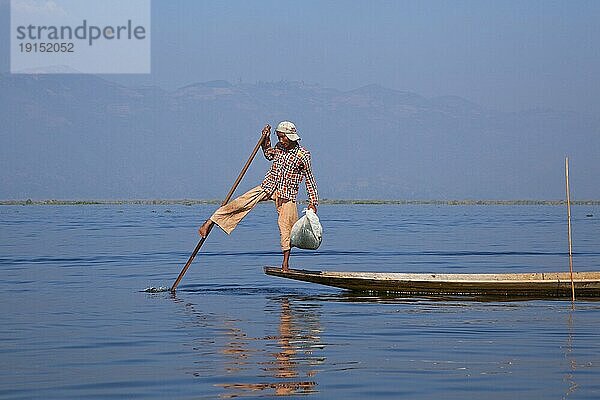 Inthafischer der ein traditionelles Fischerboot steuert  indem er sein Bein um das Ruder schlingt  Inle See  Nyaungshwe  Shan Staat  Myanmar  Birma  Asien