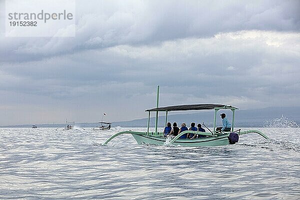 Einheimische Fischer in traditionellen Auslegern mit Touristen bei einer Delphinbeobachtungstour am Lovina Beach  Buleleng Regency auf der Insel Bali  Indonesien  Asien