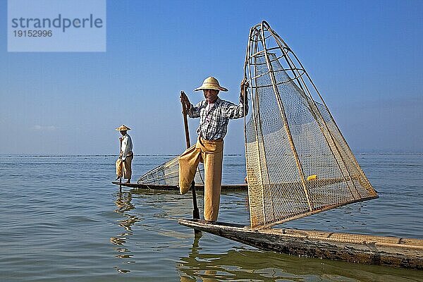 Zwei Inthafischer steuern traditionelle Fischerboote  indem sie ihr Bein um das Ruder wickeln  Inle See  Nyaungshwe  Shan Staat  Myanmar  Birma  Asien