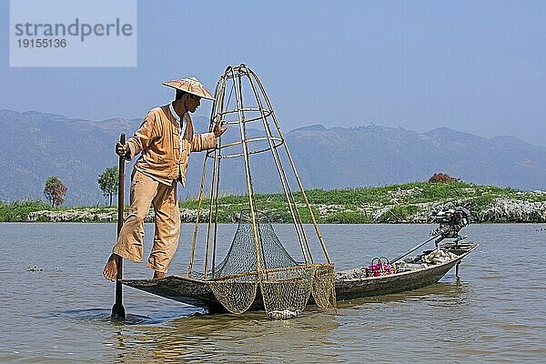 Inthafischer der ein traditionelles Fischerboot steuert  indem er sein Bein um das Ruder schlingt  Inle See  Nyaungshwe  Shan Staat  Myanmar  Birma  Asien