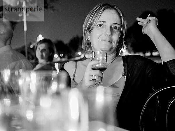 Frau bei Dinnerparty im Freien im Sommer  rauchend und trinkend  schwarzweiß