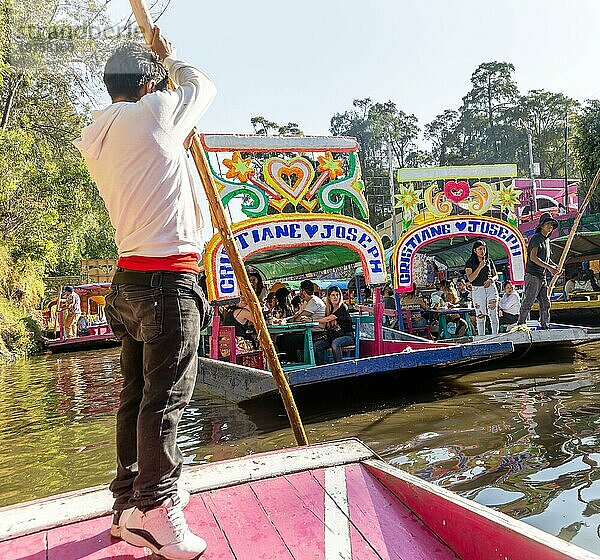 Beliebte Touristenattraktion: Menschen fahren auf bunten Kähnen auf dem Kanal von Xochimiloco  Mexiko Stadt  Mexiko  Trajinero Stocherkahn  Mittelamerika