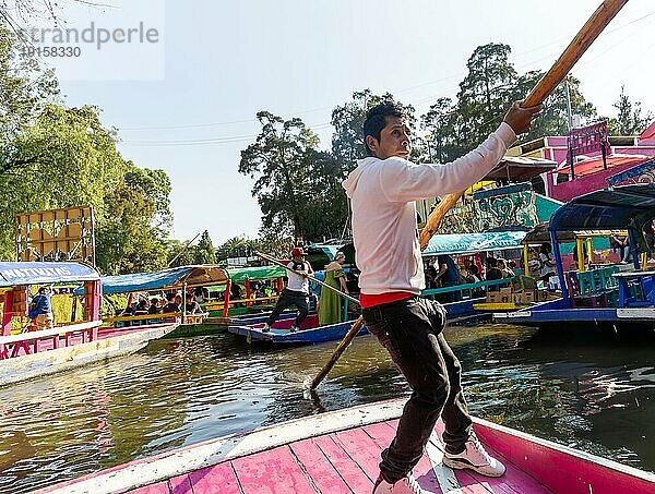 Beliebte Touristenattraktion: Menschen fahren auf bunten Kähnen auf dem Kanal von Xochimiloco  Mexiko Stadt  Mexiko  Trajinero Stocherkahn  Mittelamerika