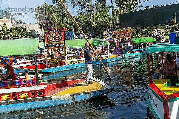 Beliebte Touristenattraktion: Menschen fahren auf bunten Kähnen auf dem Kanal von Xochimiloco  Mexiko Stadt  Mexiko  Trajinero Stocherkahn  Mittelamerika