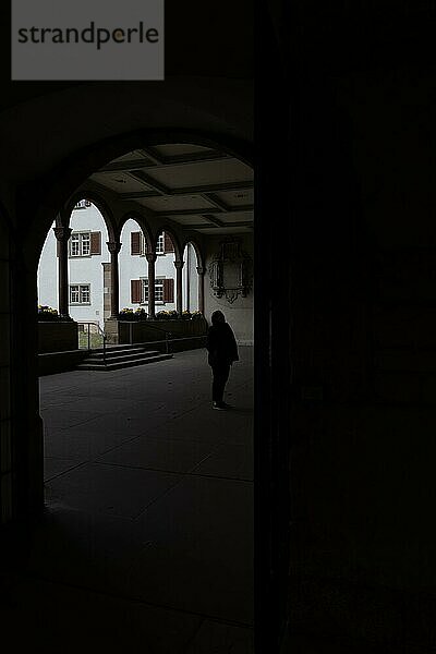 Frau in Silhouette stehend in einem Innenhof mit Bögen in der Münsterkirche in Schaffhausen  Schweiz  Europa