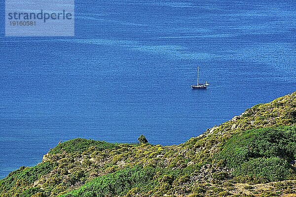 Einzelne Segelboot in ruhigen blauen Meer und grünen Hügel im Vordergrund  Luftaufnahme. Sommerurlaub  Wandern  Segeln  Abenteuer  Flucht. Milos  Griechenland  Europa