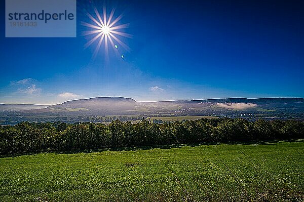 Nebel unterhalb der Kernberge über dem Ort Kunitz bei Jena mit Sonnenstern und blauem Himmel  Jena  Thüringen  Deutschland  Europa