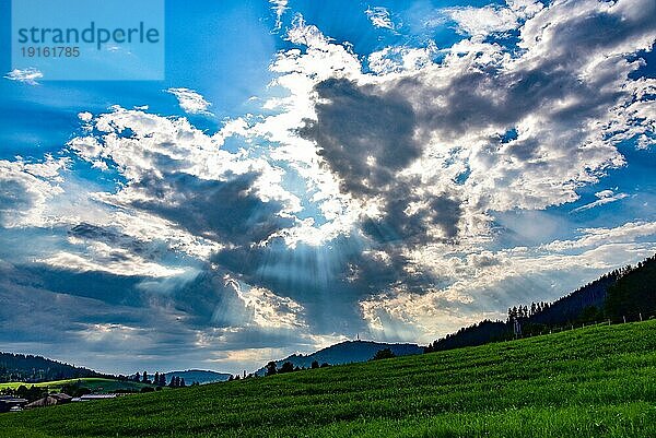 Gegenlichtaufnahme vom sommerlichen Wolkenhimmel  der den Wetterumschwung ankündigt  Allgäu  Bayern  Deutschland  Europa